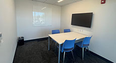 Photo of Study Room E with four chairs, a table, and LCD Monitor