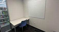Photo of Study Room C with a table, chair, and marker board