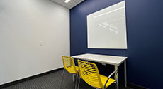 Photo of Youth Study Room B with a table, two chairs, and LCD screen