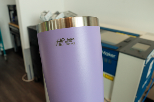 Purple stainless water bottle with the Helen Plum Library logo engraved on it