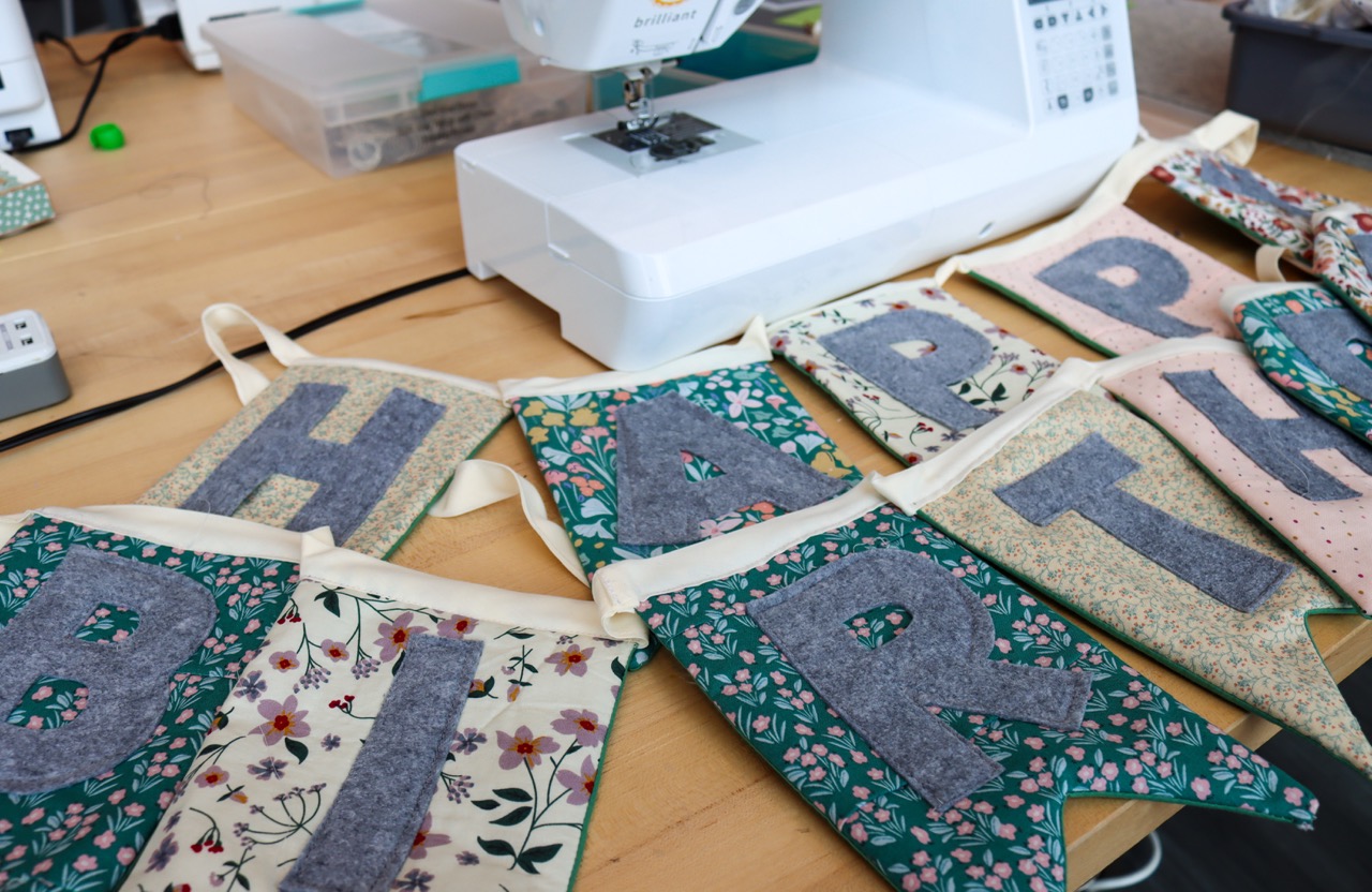 Felt banner with flags for each letter that spells out Happy Birthday.